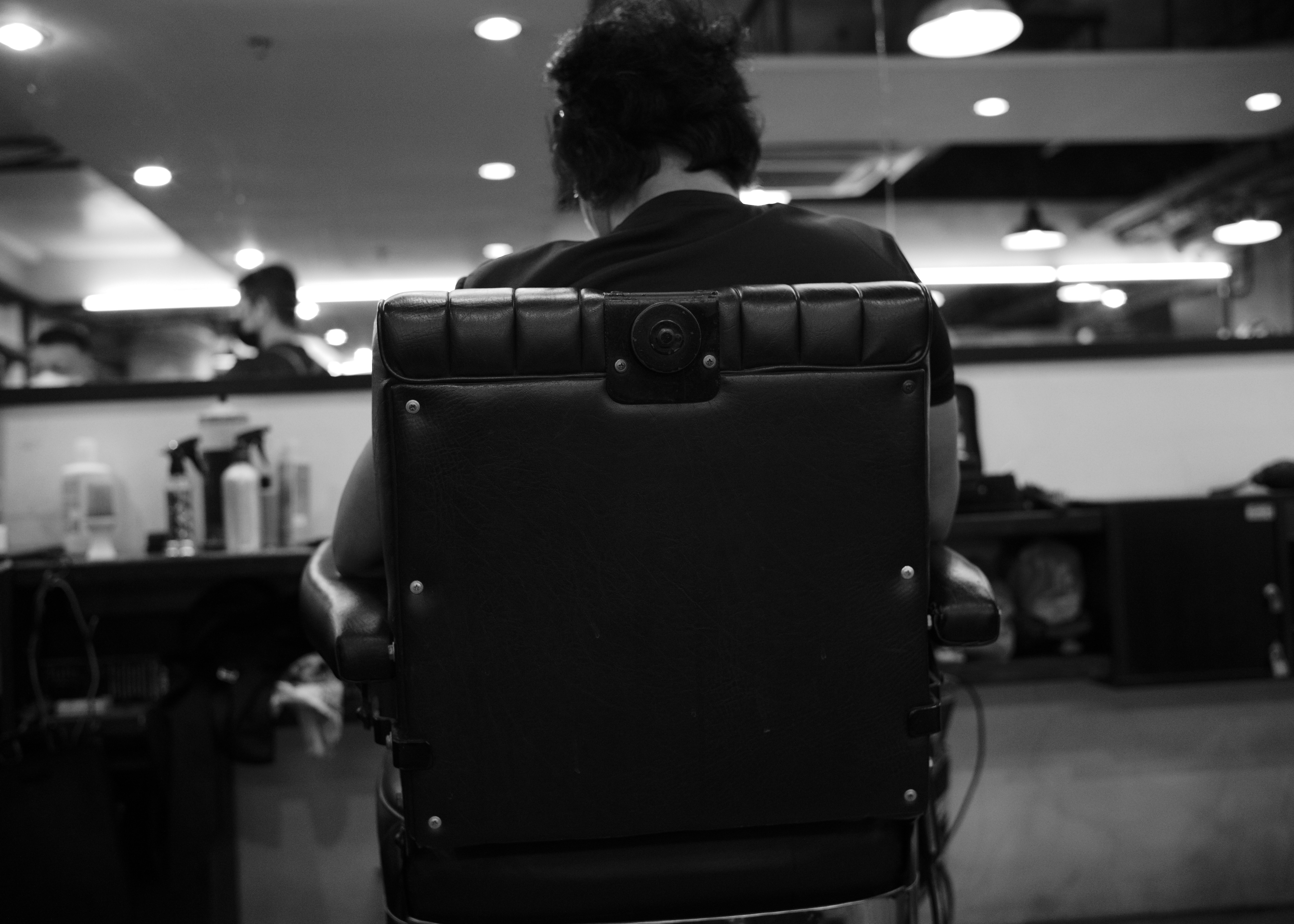 Person sitting on a barbershop chair